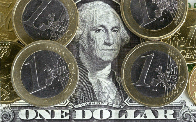 Imagen de monedas de euro sobre un billete de dólar