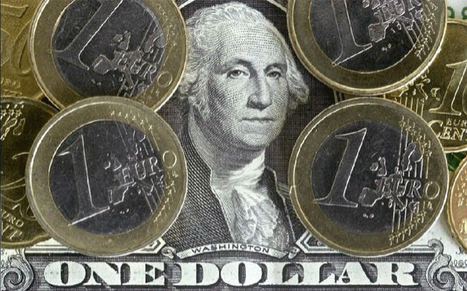 Imagen de monedas de euro sobre un billete de un dólar