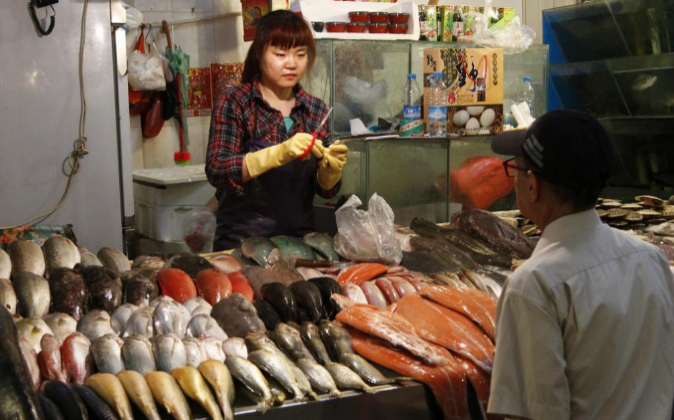 Una mujer vende pescado en un mercado en Pekín el pasado día 9 de...