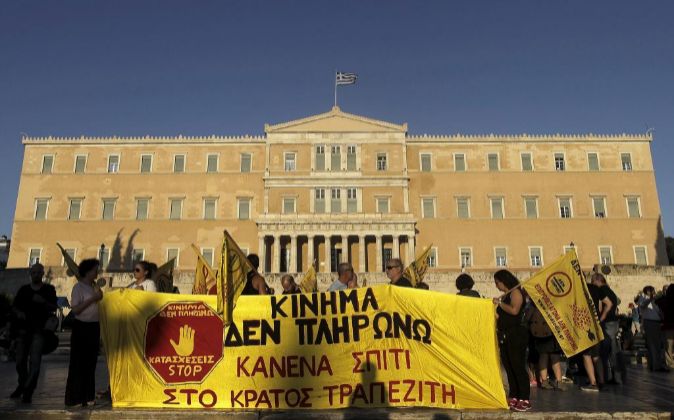 El edificio del Parlamento griego junto a unos manifestantes.