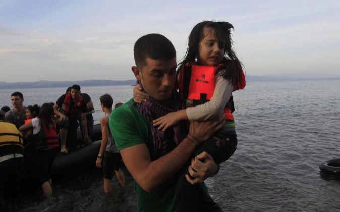 Varios inmigrantes sirios llegan en barca a la costa.