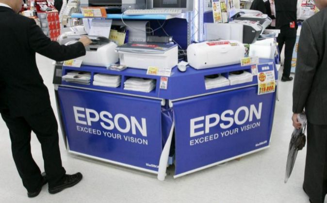Varios hombres de negocios japoneses observan varias impresoras Epson