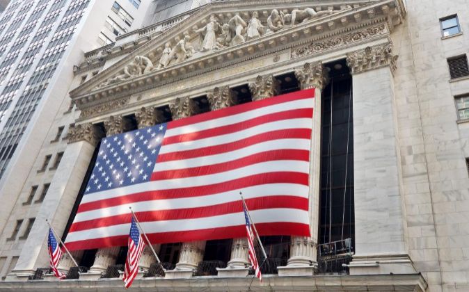 Fachada de la Bolsa de Nueva York cubierta con la bandera de EEUU.