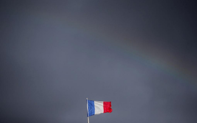 La bandera francesa ondea bajo un arco iris en lo alto de la Embajada...
