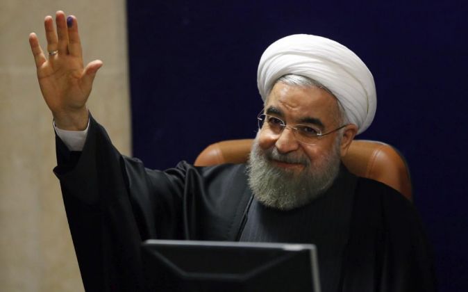 El presidente iraní, Hasán Rohaní, saluda a los periodistas tras...
