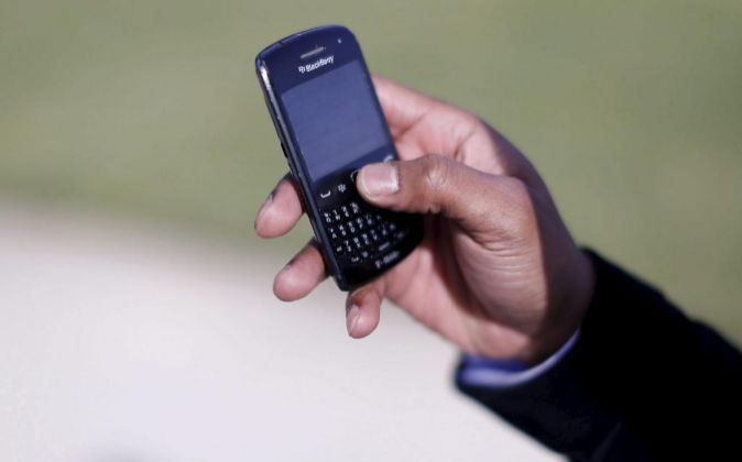 Un hombre utiliza su móvil de la marca Blackberry.