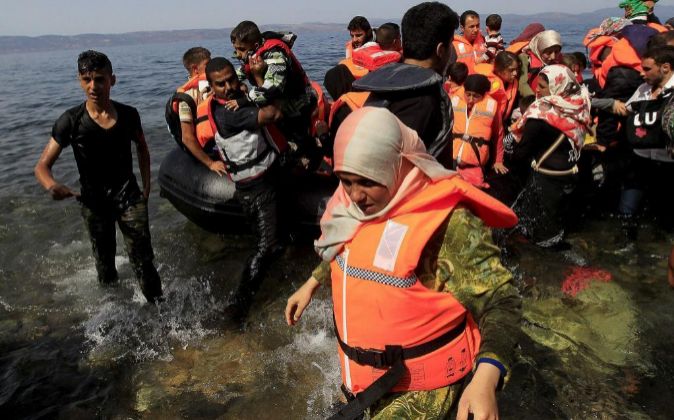 Varios refugiados sirios llegan en una lancha neumática a la costa de...