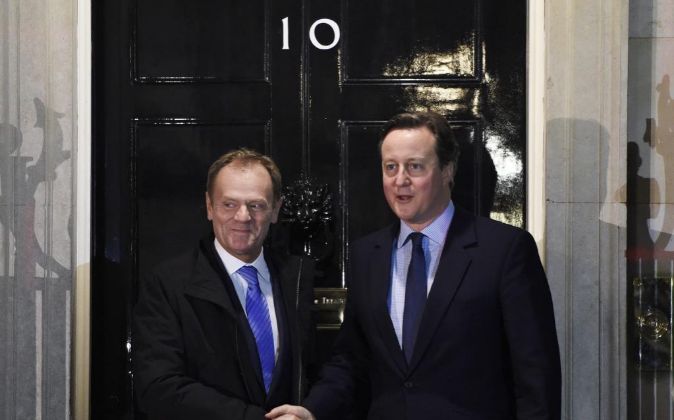 El primer ministro británico, David Cameron (d), estrecha la mano del...