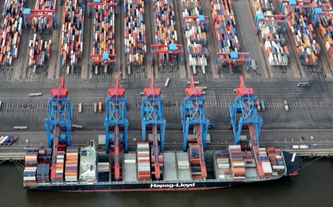 Varias grúas descargan contenedores de un buque carguero en el puerto...