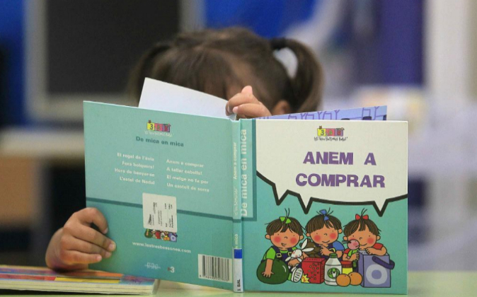 Una niña mira un libro en el colegio Josep Maria Jujol, de Barcelona,...