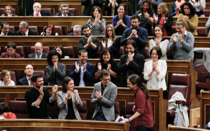 El líder de Podemos, Pablo Iglesias, es aplaudido por los diputados...