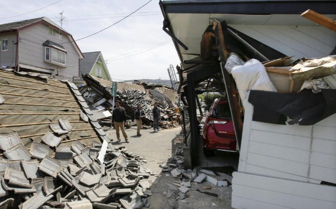 Vecinos caminan entre los escombros tras el terremoto de 6,5 en la...