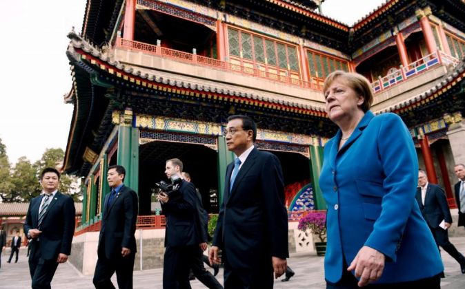 La canciller alemana, Angela Merkel, pasea junto al primer ministro...