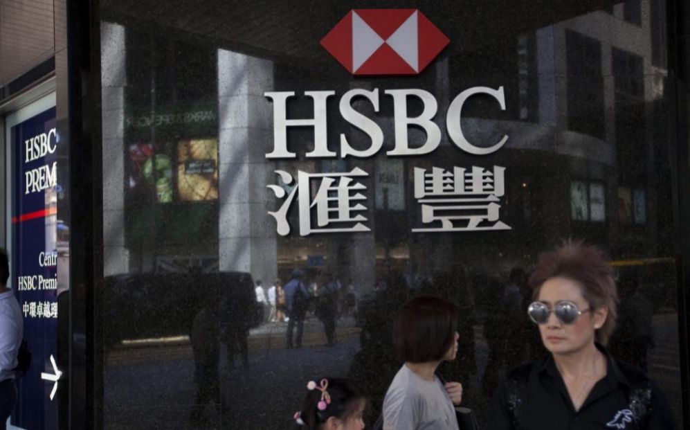 Varias personas caminan junto a una sucursal del banco HSBC en Hong...