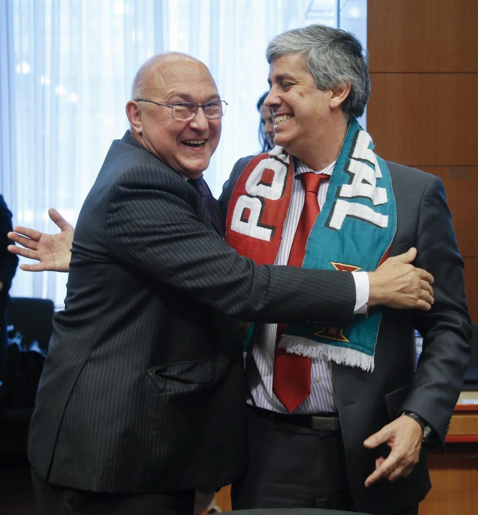El ministro portugués Mario Centeno (d) es felicitado por el ministro...