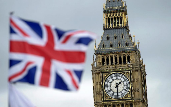 Una bandera británica ondea junto al Big Ben de Londres, Reino Unido,...