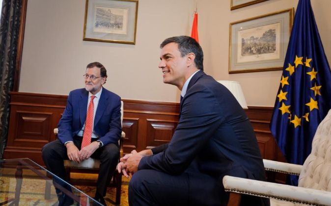 El presidente del Gobierno en funciones, Mariano Rajoy (d), y el...
