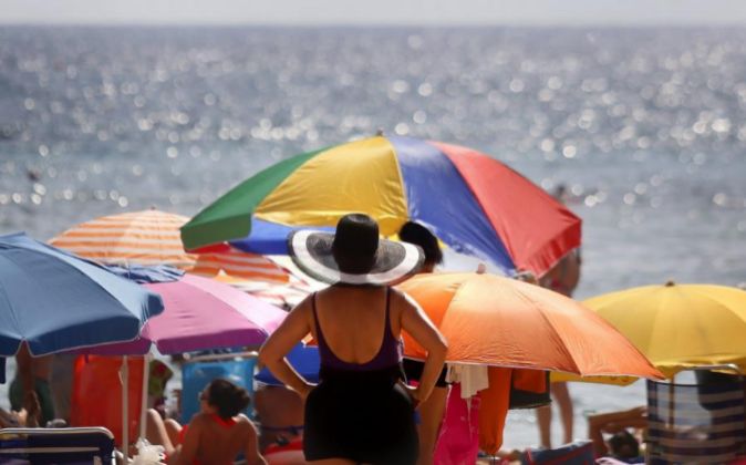 Centenares de turistas disfrutan del sol y el agua en la playa de...