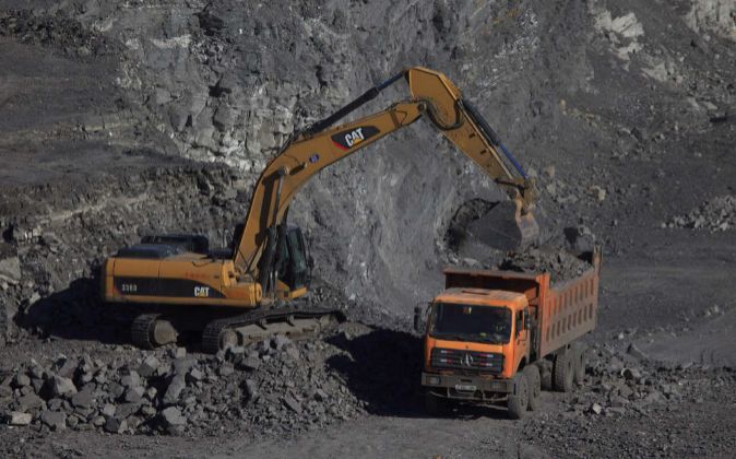 Un camión de carga es abastecido por una grúa en la mina de carbón...