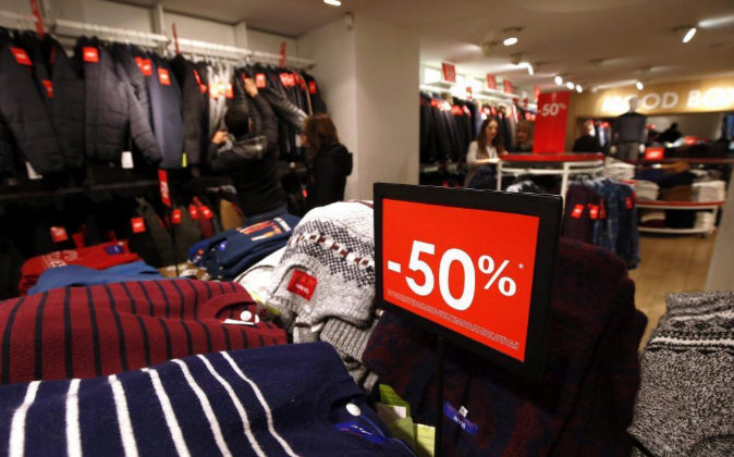Un cartel anuncia el 50% de descuento en una tienda de ropa durante...