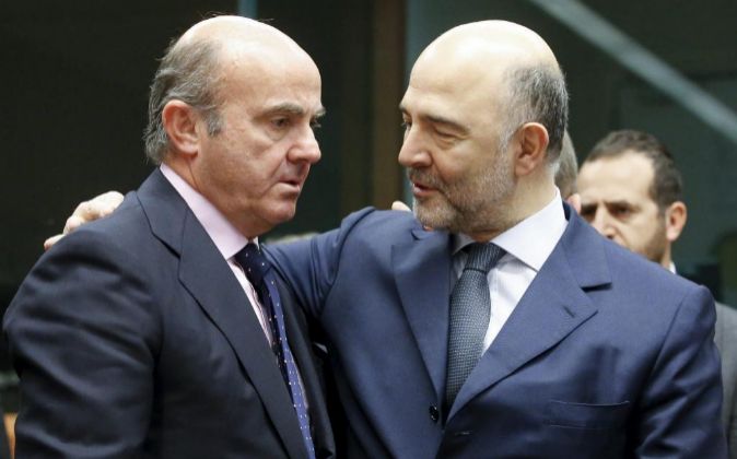 El ministro español de Economía, Luis de Guindos (i) conversa con el...