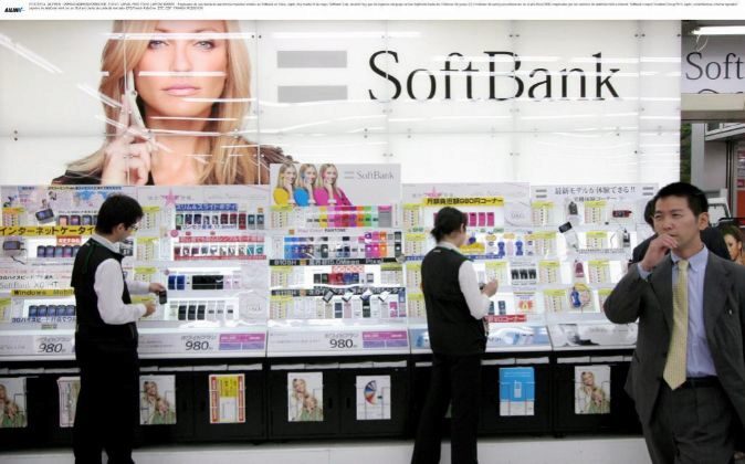 Empleados de una tienda de electrónica muestran móviles de Softbank...
