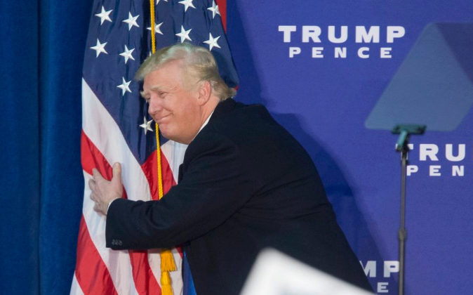 El presidente de Estados Unidos, Donald Trump, abrazando la bandera
