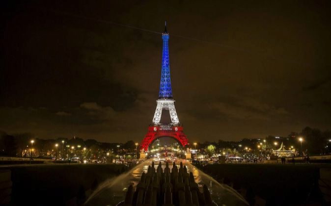 Vista de la torre Eiffel iluminada con los colores de la bandera...