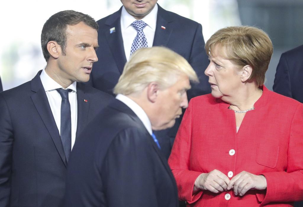 Trump pasa por delante de Angela Merkel y Emmanuel Macron durante la...