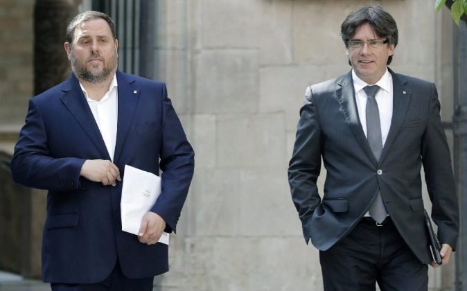 El presidente de la Generalitat, Carles Puigdemont (d), y el...