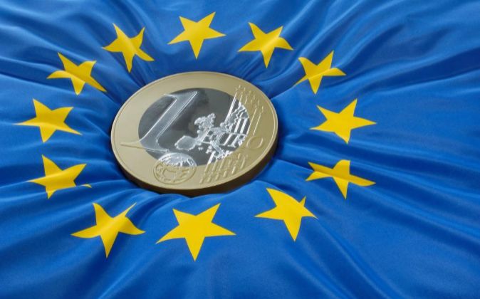 Moneda de euro sobre la bandera de la Unión Europea.