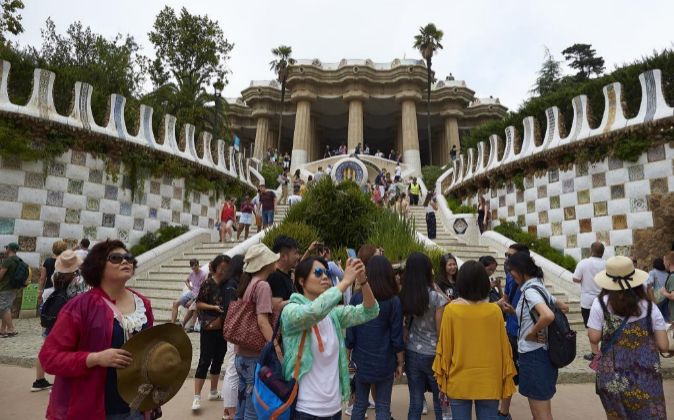 Numerosos turistas paseaban por la zona monumental del Park Güell de...