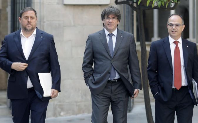 El presidente de la Generalitat, Carles Puigdemont (c), junto al...