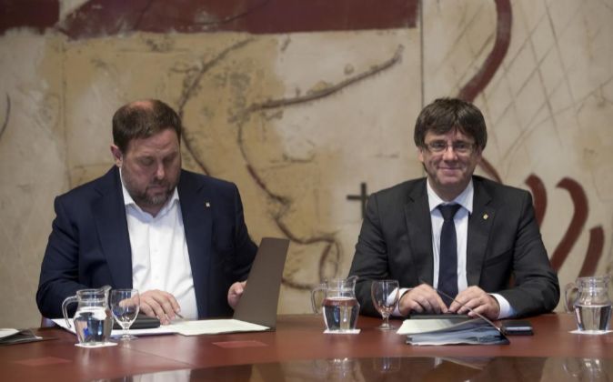 El presidente de la Generalitat, Carles Puigdemont (d), y el...