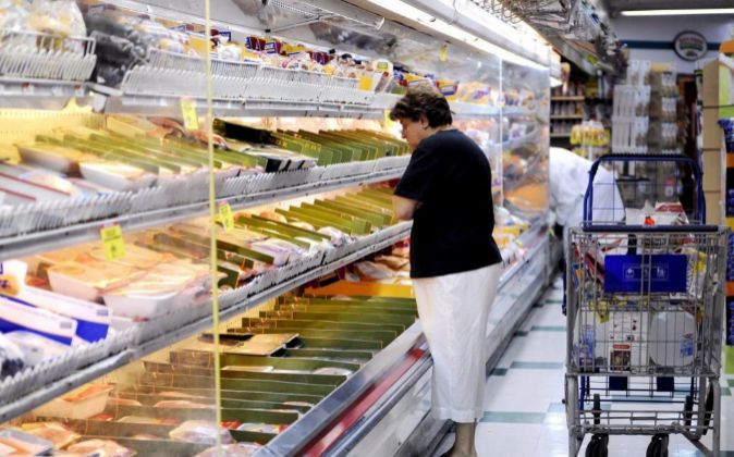 Una mujer selecciona productos en un supermercado de Brooklyn, Nueva...