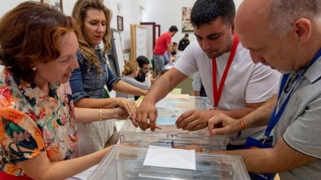 Los componentes de una mesa electoral del colegio Infantes de Toledo se disponen a abrir las urnas para el recuento de votos de las elecciones el 26M.