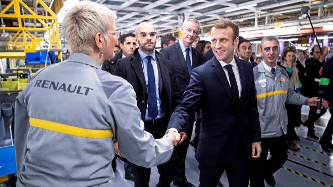 Macron saluda a una operaria de Renault. Fiat ha retirado la oferta de...