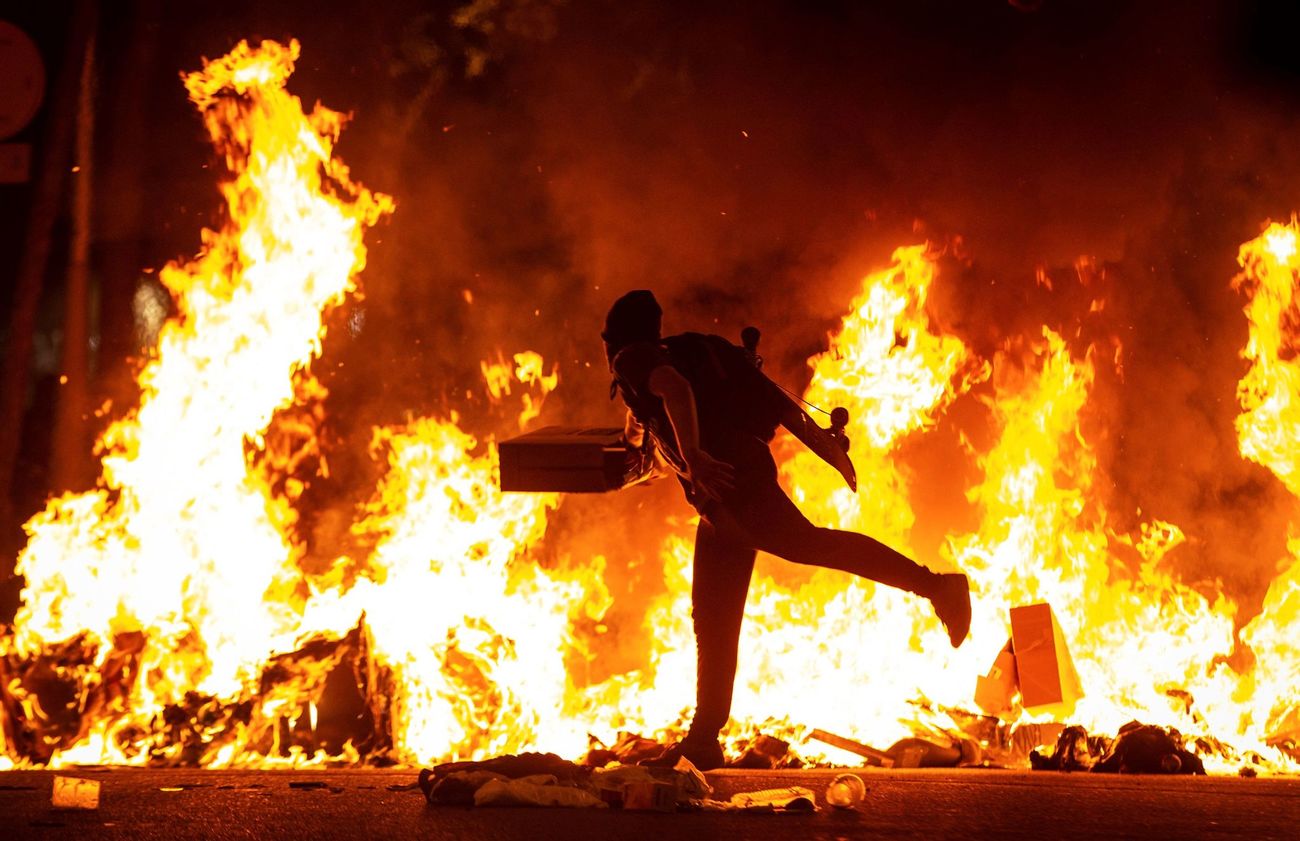 Un manifestante echa al fuego un cartn junto a la Delegacin del...