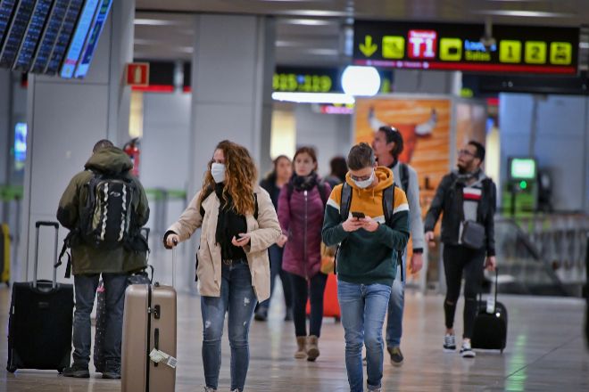 Pasajeros con mascarillas en la Terminal 2 de Aeropuerto de Madrid -...