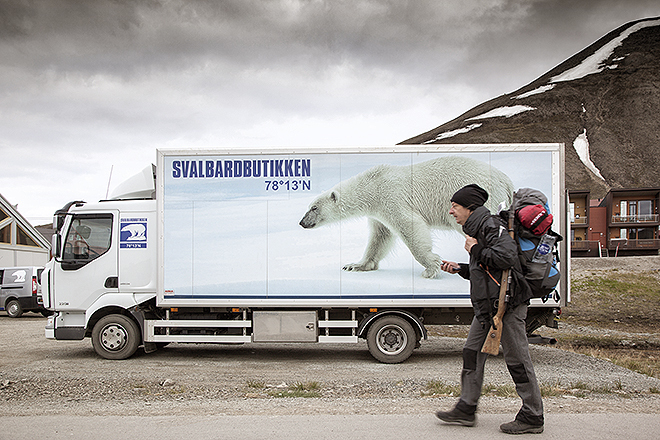 Un hombre camina con la escopeta al hombro para defenderse de un posible ataque de osos polares que, en este remoto archipiélago, superan en número a los humanos.