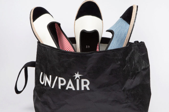 Los tres zapatos de UN/PAIR en la bolsa reciclada e impermeable en la que se comercializan. 