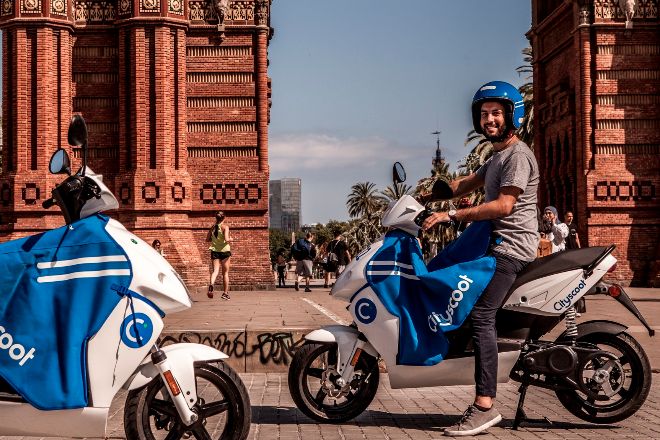 Motos de Cityscoot junto al Arco del Triunfo de Barcelona.