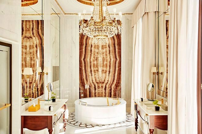 Baño principal de la Royal Suite, con una enorme bañera redonda de mármol Michelangelo pulido presidida por un inmenso mural de Onix Vida. 