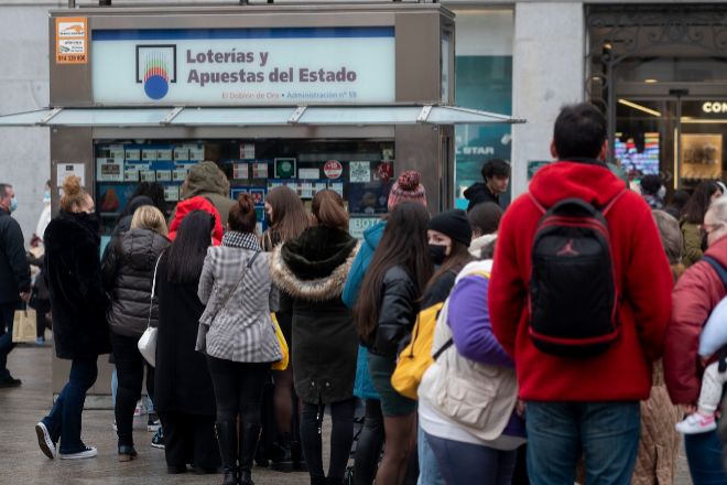 Varias personas hacen cola en una administración de Loterías del centro de Madrid.