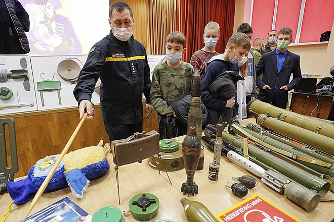 Un miembro de la defensa civil enseña material explosivo a los alumnos de una escuela de Kiev, la capital de Ucrania.