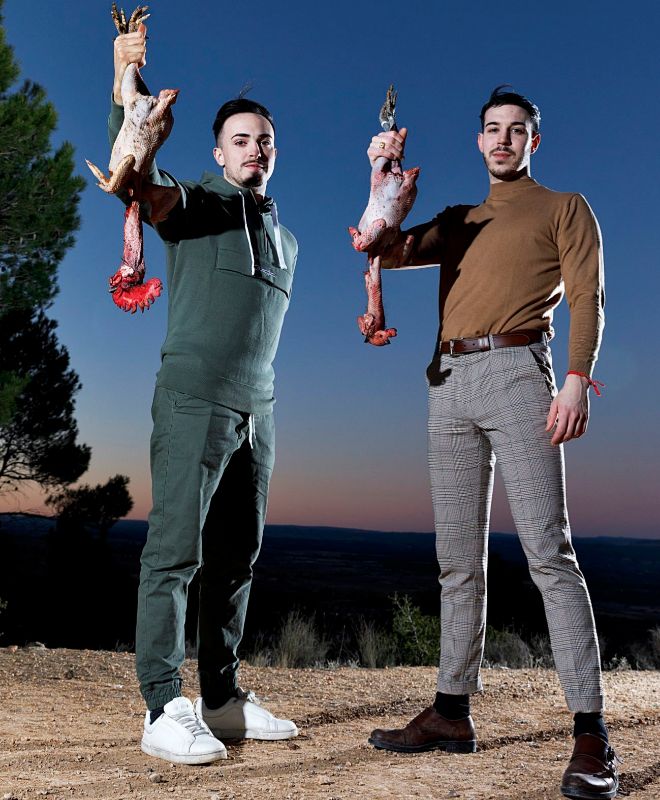 Javier Sanz y Juan Sahuquillo, ambos de 23 aos, posan desafiando el fro manchego con sendos gallos negro castellano en sus manos.      