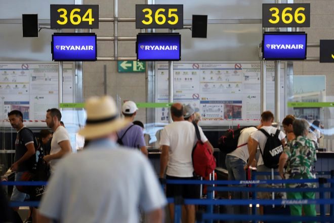 Cientos de turistas hacen colas en los puestos de embarque de Ryanair ayer en el Aeropuerto Costa del Sol.