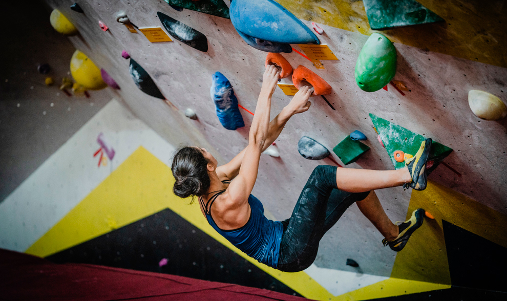 Una mujer practica la escalada deportiva en una pared con inclinacin...