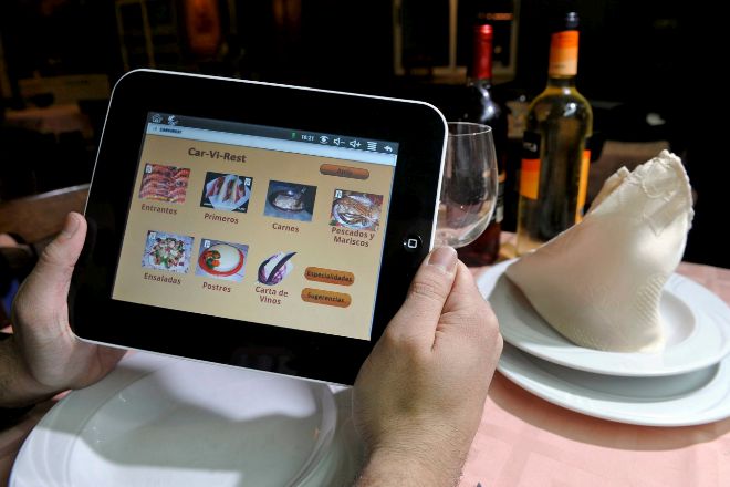 Una persona consulta el menú de un restaurante en su tablet.