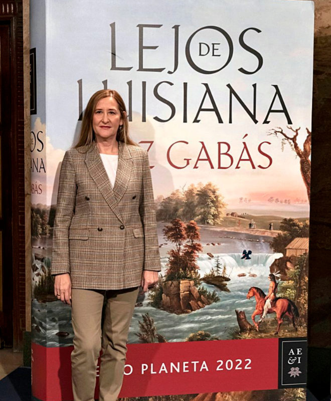 Luz Gabás, ganadora del premio Planeta 2022, junto a la portada de su libro "Lejos de Luisiana. 